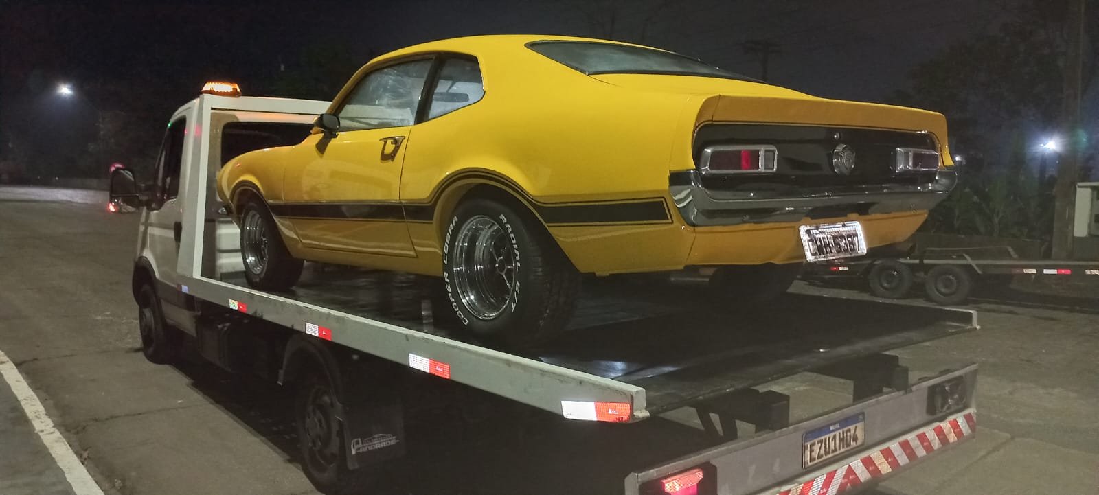 Ford Maverick amarelo clássico no guincho plataforma
