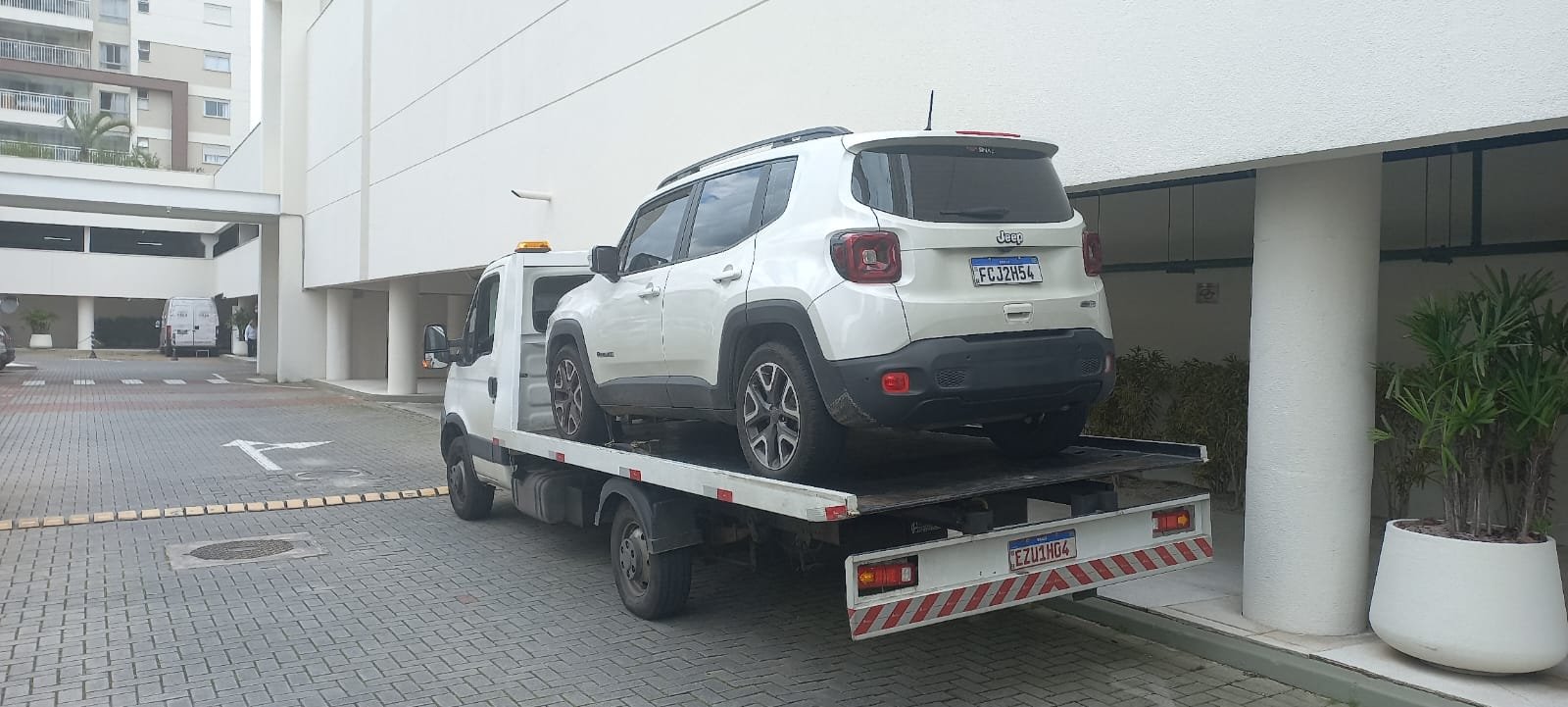 Jeep Renegade branco transportado em plataforma Cammilog
